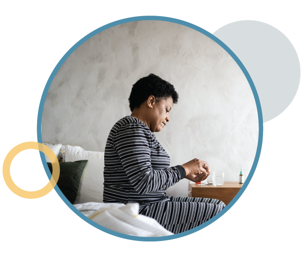 Woman in pajamas sitting in a bed.